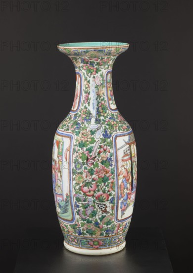 Cantonese vase, Canton China, 19th century. Ovoid body with thin neck and two side handles; rib with upwardly curled edge and plastically separated foot. Thick grayish porcelain body with white glaze tinged grey. Decoration: two reserved figural court scenes on body and neck set against backgrounds of flowers, birds, butterflies and fruit; painted in overglaze enamels two greens, blue, yellow, red, pink, black, overglaze iron red and gilding. Colored porcelain decorative vessel, height 63 cm, diameter 28 cm., A tall ceramic vase with a flared rim sits against a dark background, decorated all over with intricate floral and figurative panels; the surface shows a palette of green, pink, blue, red, yellow, and white, with touches of black outlining; a group of floral motifs and fruit-like shapes cover much of the body, interspersed with framed scenes depicting human figures and architectural elements; the neck and shoulder are filled with dense foliage and flowers, and the base and rim are...
