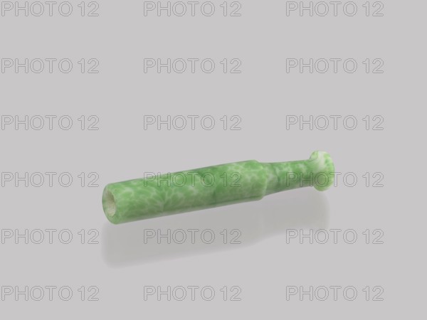 Cigarillo, Chinese, Qing 1644–1911, smoking tobacco pipe, cast glass, green and white, 19th century, China, height 7.9 cm, diameter 1.35 cm, A single elongated cylindrical object with a slightly flared end rests on a smooth surface, showing a glossy finish and a subtle reflection beneath it. The object displays a mottled pattern of light green and pale green with some whitish areas creating a marbled appearance. The background and surface are a very light gray, and the object's interior at the open end appears off-white or pale beige.