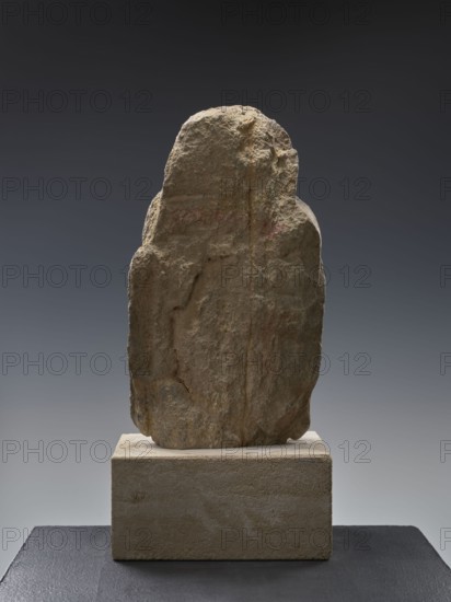 Head of Buddha, unknown sculptor; Chinese; Qing 1644–1911 and Song 960–1279 stylistic influences; Chinese Buddhism iconography; Buddha ca. 560–480 BCE; ushnisha; Song-style sculpture; 19th–20th century; China; sculpture; height 38.0 cm, A roughly rectangular, weathered stone with an irregular, textured surface sits upright on a rectangular block base; the stone shows uneven edges, small pits, and vertical grooves with visible rough contours. The stone displays tones of beige, light brown, sandy tan, and hints of gray, with subtle darker brown areas and faint reddish patches. The base is a lighter sandy beige with a slightly rough finish, and the platform beneath the base appears dark gray to black. The background transitions from dark gray at the top to a lighter gray toward the bottom, creating a neutral gradient behind the stone.