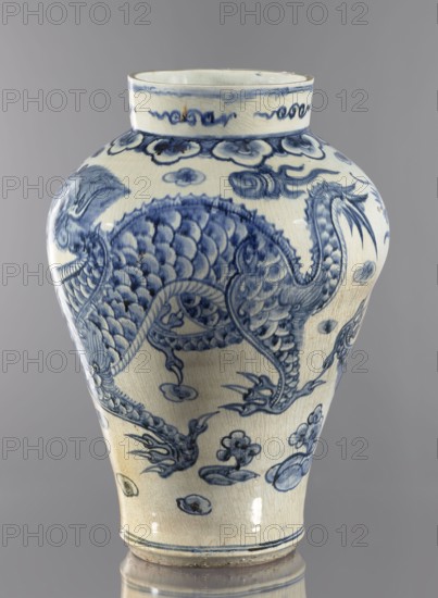 Ovoid vase with a long neck, maebyeong type Chinese: mei-ping. 18th century, Korea. Porcelain vessel, height 46.0 cm, width 32.0 cm, weight 8.0 kg. Decoration: two dragons among clouds. Korean Joseon, 1392–1897 — Korean art., A ceramic vase with a rounded body and narrow neck standing against a plain gray background, decorated in blue on an off-white base with a crackled surface; flowing blue motifs include a stylized dragon with scaly texture, curling tail, sharp claws, and sinuous limbs surrounded by cloud- and floral-like forms, with decorative bands near the rim and base, and visible areas of darker blue shading and lighter washes that emphasize the painted details.