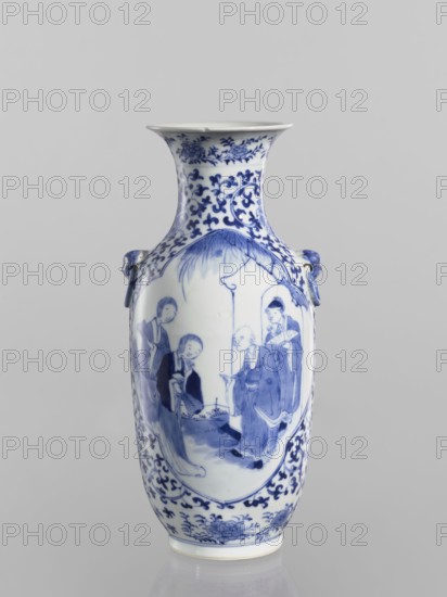 Vase, Chinese, Qing dynasty Kangxi period, 1662–1722. Ovoid blue-and-white porcelain vase with a flaring cup-shaped mouth. On the shoulders are two applied mascarons with wheeled elements. Underglaze cobalt-painted decoration: figural scenes in two quatrefoil reserves; background plant ornament with small leaves and large floral rosettes, lotus tendril ornament, fans, lotuses. Signed. Height 25.5 cm; diameter 11.1 cm., A tall porcelain vase with a flared rim featuring blue decorative patterns on a white background, showing a painted scene of several human figures in traditional clothing within an oval panel, surrounded by floral and scrolling motifs; the vase has a pair of small sculpted handles on the shoulders and displays colors of blue and white.