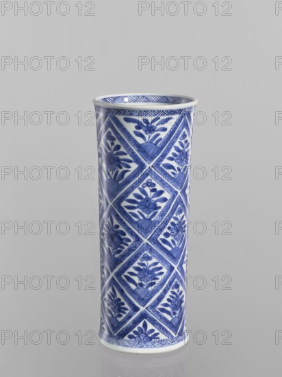 Vase, Chinese, blue-and-white porcelain, ceramics; cylindrical vessel with geometric and floral ornaments including rhombuses; 18th century China; height 23.2 cm, diameter 9.6 cm., A tall cylindrical ceramic vase with a glossy finish standing upright against a plain light gray background, decorated all over in a blue and white palette with a repeating diamond grid pattern, each diamond containing a stylized floral motif, and a narrow patterned band around the rim and base.