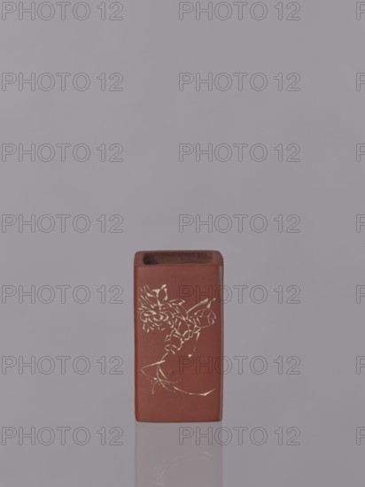 Vessel, Japanese art, Japanese culture, engraved decorations, ceramics, flowers iconography, red-brown stoneware; engraved decoration, dyed white with engobe, 19th century, Japan, vessel, height 11.1 cm, width 6.3 cm, depth 6.3 cm, A rectangular ceramic container in reddish-brown sits centered against a light gray background, showing a faint reflection below; the front surface features a delicate floral design in a metallic gold color, and the container's top opening reveals a darker brown interior.