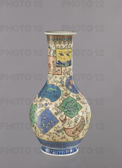 Vase, Japanese, insects, colored porcelain, butterflies, vases, floral decorations, geometric ornaments, ceramics, provenance noted, Meiji 1868–1912, cloisonné enamel, ca. 1870–1880 Meiji Period, Japan, Nagoya, vessel, height 39.5 cm, diameter 20.5 cm, A tall ceramic vase with a narrow neck and bulbous body sits against a neutral gray background; the vase displays a cream base color decorated with a patchwork of ornamental panels and medallions in blue, green, yellow, pink, and turquoise, with small black floral and vine motifs filling the spaces between panels; the neck has a band of green and red geometric pattern beneath the rim, and the lower body shows blue and green square and circular panels containing floral and landscape-like motifs, along with accents of red and brown and tiny scattered decorative elements; the foot of the vase is highlighted with a band of deep blue and lighter blue detailing.