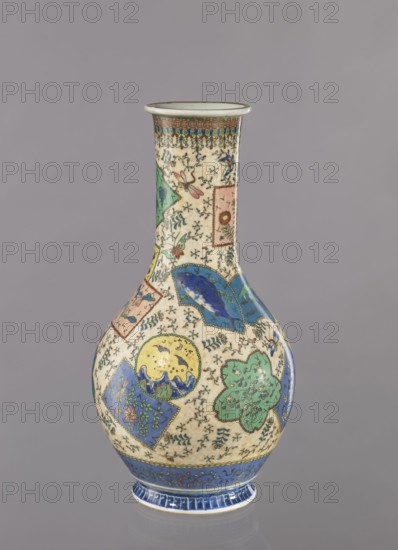 Vase, Japanese, colored porcelain and cloisonné enamel, decorated with insects and butterflies, floral decorations and geometric ornaments; Meiji period ca. 1870–1880; Nagoya, Japan; vessel; height 39.5 cm, diameter 20.5 cm., A rounded ceramic vase with a narrow neck standing against a plain gray background, decorated with a patchwork of ornamental cartouches and floral motifs; the surface shows a cream base with intricate small black vine-like patterns and areas of blue, green, yellow, pink, and red forming stylized flowers, leaves, and abstract shapes, with a band of blue decoration around the base and a patterned rim at the top.