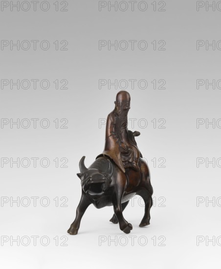 Shoulao on a buffalo — incense burner; creator, Chinese; men; buffaloes; Taoism; incense burner; sage; Shouxing iconography; Qing dynasty 1644–1911, 19th century; sculpture/figurine; height 20.7 cm; width 20.7 cm, A dark brown wooden sculpture of an elderly man with a long beard seated on the back of a water buffalo, the man wearing flowing robes and holding a small object in one hand, the buffalo shown with curved horns, a broad head, and sturdy legs, the surface of the sculpture showing varying brown tones with some areas of darker patina, set against a light gray to white gradient background.