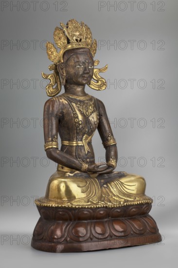 Amitayus, creator unknown, Buddhist/Tibetan/Himalayan/Mongolian art; Himalayan and Mongolian cultures; Buddha iconography with ushnisha, lotus throne, and vajras; 2nd half of the 18th–1st half of the 19th century; Inner Mongolia origin; sculpture/figurine cult object; height 37.5 cm; weight 2.12 kg., A seated statue of a figure on a rounded lotus base, rendered in dark brown and gold tones, with a dark brown body and gilded highlights on the headpiece, chest, belt, arms, and lower garment; the figure wears an ornate multi-lobed crown with decorative elements in gold and small green accents, and has stylized gold ear ornaments and flowing gold ribbons at the sides of the head; the torso shows decorative gold patterns and circular motifs, with gold bands around the upper arms and wrists and a gold sash at the waist; the hands rest in the lap in a meditative gesture and the legs are crossed beneath a draped gold lower garment that has carved folds; the lotus base is dark brown with carved...