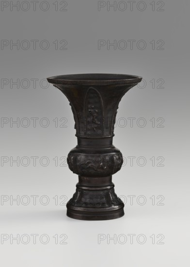 Gu-type vessel, gu cups, Chinese art, Chinese culture, ceremonial vessels, Qing 1644–1911, ritual vessels, 18th century, China, vessel; height 15 cm, diameter 10.7 cm, A dark brown metal vessel with a flared rim and a tall, tapering body standing on a rounded base, featuring raised decorative panels and carved motifs on its upper and lower sections, shown against a neutral gray background that fades from darker at the top to lighter toward the bottom.
