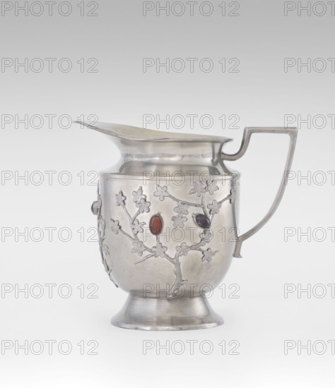 Jug; maker, plant ornament, fruit ornament; Chinese; Qing dynasty 1644–1911, 19th century; applied plastic decoration of flowering leafy bunches with oval semi-precious stones; motifs include plum trees; function: vessel/teapot; height 20.6 cm, width 23.0 cm; provenance unknown., A silver pitcher with a curved spout, a straight angular handle, and a flared pedestal base is shown against a pale gray background; the body of the pitcher is decorated with raised floral and branch motifs and a few oval stones set into the surface, with visible colors including silver, red, purple, and a hint of brown.