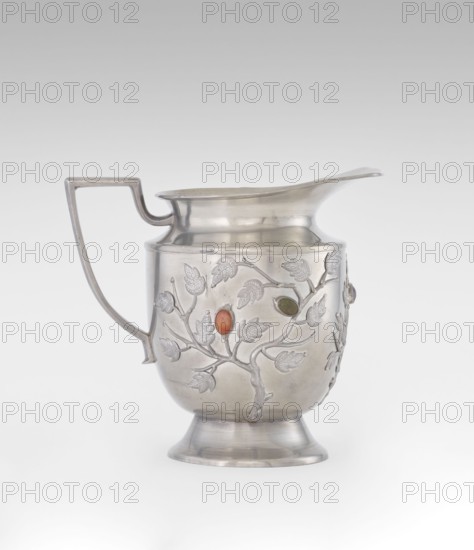 Jug, plant ornament, Chinese, Chinese art, teapots, fruit ornament, applications, plum trees, Qing 1644–1911, applied plastic decoration: flowering, leafy bunches with oval set semi-precious stones, 19th century, China, vessel, height 20.6 cm, width 23.0 cm, A metal pitcher with a curved spout and an angular handle sits against a pale gray background; the pitcher has a rounded body on a flared foot and a decorative raised branch-and-leaf pattern on its surface with a few oval colored insets in shades of orange and green, and the metal shows a reflective silver tone with subtle highlights and shadows.
