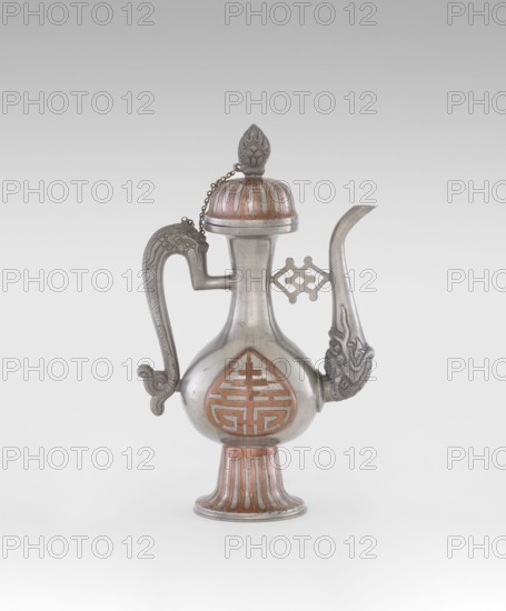 Wine jug, Chinese, plastic decorations with lotus and lotuses, longevity shou and dragons iconography, Qing 1644–1911, early 20th century, China, vessel; height 26.8 cm, width 17.5 cm, An ornate metal ewer with a rounded body on a flared, ribbed pedestal base, featuring a curved spout with a decorative animal head at its base and a sculpted handle with a curled end; the vessel has a domed lid topped by a pointed finial connected to the body by a small chain and shows inlaid or painted accents in reddish-brown against the silvery metal, with additional raised decorative motifs on the body and near the spout.