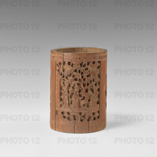 Brush vessel, Chinese, Qing 1644–1911, early 20th century. Porcelain container with bas-relief reserves depicting figural scenes in a landscape and images of birds. Height 16.4 cm; diameter 11.9 cm., A cylindrical wooden object with a warm brown tone sits against a neutral gray background; its surface features intricate openwork carvings depicting a scene with human figures and stylized trees, surrounded by carved decorative borders and repeating patterns, and the wood shows natural grain variations and some darker and lighter brown areas.