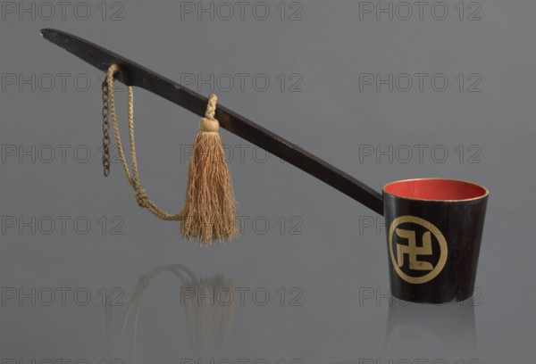 Ritual ladle, Chinese, Qing 1644–1911, Chinese Buddhism ritual vessel with swastikas painted gold. A chain and silk cord with a tassel hang from the handle. Late 19th century, China; length 57.5 cm.