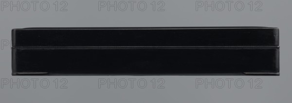 Ink stone box; maker, ink; container; Chinese and Japanese art/culture; provenance, 19th–20th century : Japan, / China ; dimensions: height 4.0 cm; width 16.0 cm; depth 22.5 cm., A rectangular black box with a lid sits centered against a solid light gray background; the box shows subtle surface reflections and scuff marks and appears to be made of a smooth, slightly glossy material with edges that are slightly rounded.