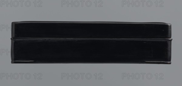 Ink stone box, ink; container., Materials: ink. Culture: Chinese, Japanese. Date: 19th–20th century . Place of origin: Japan, China . Function: container. Dimensions: height 4.0 cm; width 16.0 cm; depth 22.5 cm., A rectangular box with a smooth, glossy surface, shown from the front with a visible lid seam; the box is predominantly black with subtle highlights and reflections suggesting a polished finish, and it rests against a uniform gray background.