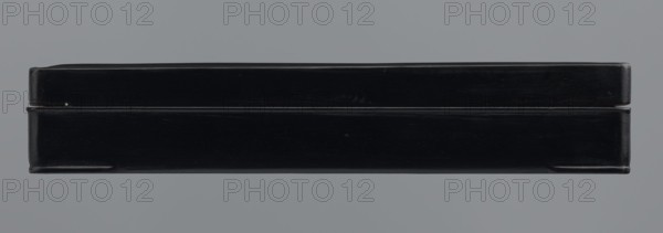 Ink stone box, ink container, Chinese and Japanese art and culture, provenance unknown, 19th–20th century, origin possibly Japan or China, container; height 4.0 cm, width 16.0 cm, depth 22.5 cm, A horizontal rectangular black object with a glossy finish sits centered against a flat gray background, showing a top and bottom section separated by a narrow horizontal gap; the object has slightly rounded corners and subtle surface scratches and highlights, with visible small scuffs and a faint sheen reflecting gray and slightly lighter black tones.