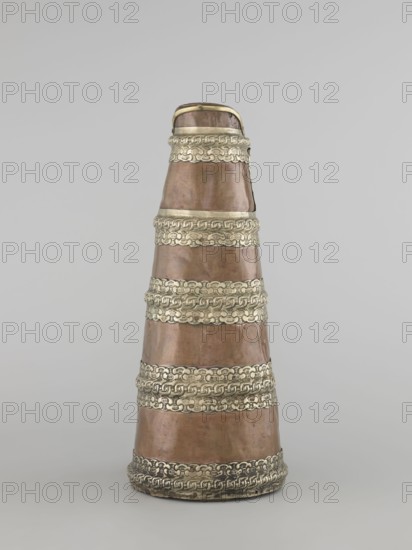 Tea pot, maker, craft: vessel teapot/kettle, Tibetan; 19th century; jug tapering towards the top with silver fittings and brass handle; height 35.0 cm, width 19.0 cm, diameter 15.0 cm., A conical object stands upright against a neutral light gray background, showing a metallic surface with alternating bands of warm copper and decorative silvery trim; the copper areas have a muted brownish-red patina with subtle uneven sheen and small surface imperfections, while the silver-colored bands feature raised interlocking patterns and textured detailing; the top narrows with a small rounded rim and the base flares slightly with a darker ring where the silver band sits, and overall the colors visible are copper, silver, gray, brownish-red, and hints of darker tarnish.