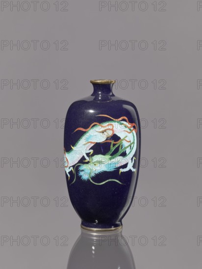 Vase, repousse?; dragons iconography; Japanese art; Japanese dragon motif; Meiji 1868–1912; cloisonné enamel on silver; vase on a low ring-shaped foot with a short thin neck slightly flared at the spout; 19th–20th century Meiji period, Japan; vessel; height 11.8 cm, diameter 6.1 cm., A dark blue vase with a glossy finish stands against a gray background, featuring a painted dragon motif in pale blue, green, turquoise, white, red, and orange, with gold-colored rim accents at the top and base; the vase has a rounded body that tapers to a short neck and reflects on the surface beneath it.