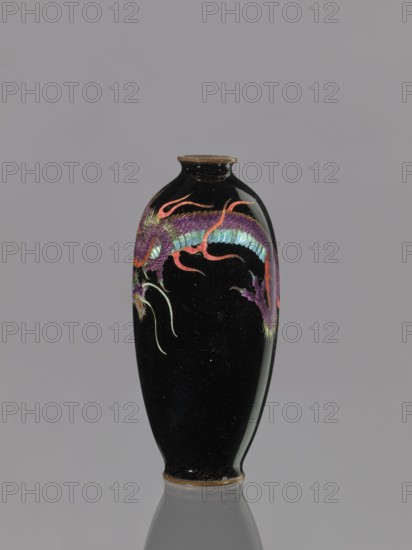 Vase;, Cloisonné enamel on copper. Japanese, Meiji period 1868–1912, 19th/20th century. Motifs: dragons, Japanese dragon, beasts fantasy. Vessel; height 11.7 cm, diameter 5.0 cm., A tall, slender black vase with a narrow neck and slightly flared rim stands against a gray background; the vase features a decorative dragon motif rendered in purple, teal, red, pink, green, and gold tones that wraps around its upper body, and the base and rim show a thin band of brownish-gold.