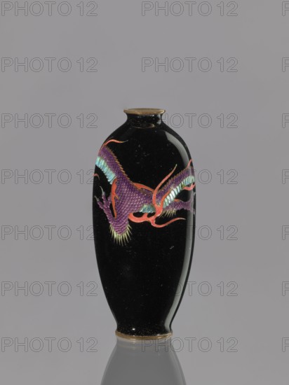 Vase, dragons iconography, Japanese dragon motif, Meiji 1868–1912, beasts fantasy, cloisonné enamel on copper, 19th/20th century Meiji Period, Japan, vessel; height 11.7 cm, diameter 5.0 cm, A black glossy vase with a narrow neck and rounded body sits against a gray background, decorated with a stylized dragon motif in purple, red, teal, and green, with gold accents at the rim and base and a reflective surface showing highlights.