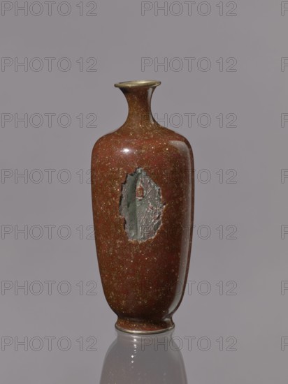 Vase with a narrow neck, flaring at the spout; decoration on a brown-brick background. Kinseki technique. 19th–20th century Meiji period, Japan. Vessel; height 17.9 cm, diameter 7.0 cm., A tall, narrow ceramic vase with a flared neck and rounded shoulders stands against a smooth gray background; its surface is a glossy reddish-brown speckled with tiny gold flecks, and there is an irregular, rough patch of matte greenish-gray texture on one side that contrasts with the polished finish, while a thin band of metallic color rings the rim and base and the vase casts a soft reflection on the glossy surface beneath it.