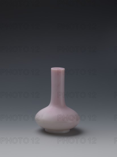 Vase, Paderewski, Ignacy Jan 1860–1941 provenance, Chinese art, Chinese culture, Qing dynasty 1644–1911, Qianlong period/style 1736–1795. Flask of pale pink glass on a low ring foot with a straight long cylindrical neck. China, 1736–1795. Vessel. Height 13.6 cm; diameter 9.8 cm; weight 0.35 kg., A single smooth vase with a rounded bulbous base and a long narrow neck sits centered against a gradient background; the vase is a soft pale pink with subtle lighter and slightly darker pink shading, and the background transitions from dark gray at the top to lighter gray toward the bottom.