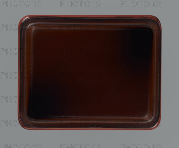 Box with a lid., Japanese art; Meiji period 1868–1912. Lacquer box with rounded corners and a slightly distinct, wavy-cut base. Black, red, brown, yellow lacquer, carved chôshitsu. Decorated with flowers, chrysanthemums, and leaves. Early 20th century. Japan. Container. Height 6.1 cm; width 14.0 cm; depth 10.8 cm; weight 208 g., A square tray viewed from above with rounded corners, featuring a glossy dark brown interior and slightly lighter brown rim, set against a gray background.