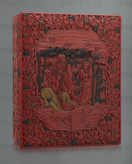 Box with a lid, Chinese art, Chinese culture, figural scenes, floral motifs, Qing 1644–1911, peonies, bamboos, geometric ornament, gourds, sages, scholars, fans, men. Decoration: on the lid a large reserve with a figural scene in a landscape; the rest of the background and sides with floral motifs. Red, black, green, and yellow lacquer, carved. 19th century, China. Container; height 13.0 cm, width 36.5 cm, depth 28.5 cm., A rectangular carved box with a predominantly red surface decorated with carved floral patterns and leafy accents in green and brown surrounds a central carved scene framed by a rounded rectangular border; the central scene depicts a group of robed figures carved in red with one reclining figure wearing a yellow robe and another seated figure wearing a yellow garment, with slender green bamboo stalks and leaves rising behind them, and stylized cloud-like carvings above; the entire object sits against a neutral gray background.