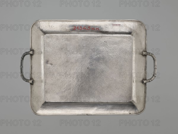 Tray, gift, Japanese art, Japanese culture, dragons, Meiji 1868–1912, Japanese dragon motif, silver, bamboos, grained background decoration, early 20th century Meiji period, Japan, vessel; height 1.7 cm, width 30.8 cm, depth 21.2 cm, A rectangular metal tray with rounded corners and a textured surface fills the image, shown against a neutral gray background; the tray has raised edges and a recessed central area with a pebbled finish, and a pair of curved handles attached at opposite shorter sides, each handle featuring segmented ridges; the metal appears mainly silver with subtle variations in tone and slight darker gray areas around the edges and handles.