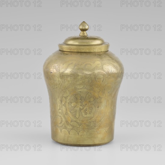 Tin with a lid; tin with the top widened; container, height 15.0 cm, diameter 9.8 cm; early 20th century, Korea; Korean art; Korean culture; ornament: plant peonies;, A brass jar with a lid, showing an overall golden color with engraved decorative patterns covering its rounded body and lid; the jar has a bulbous upper section tapering to a narrower base, a domed lid topped by a small finial, and visible engraved motifs of flowing curved lines and stylized leaf and floral shapes; the background is a neutral light gray.