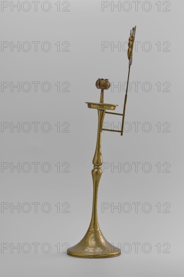 Candlestick, early 20th century, Korea; candlestick on a round base transitioning into a two-baluster shaft terminating in a flat, round sleeve with a smaller one in the shape of a multi-petaled flower bud placed in the center; ornament: butterflies and flowers; pair this is from a pair; height 39.7 cm., A tall, slender metallic object with a flared, round base and a long, gently curving stem rising to a small shallow dish and a flower-shaped cup, shown against a plain light gray background; the object is a brass tone with visible darker spots and subtle engraved decorative patterns on the base, and a thin vertical rod extends upward from the side with a few horizontal supports and an attached decorative element at the top that is brass colored with slightly darker accents.