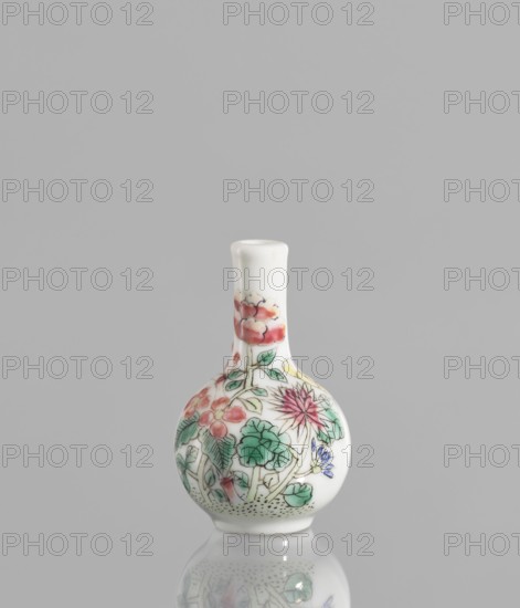 Bottle, repossession Krakow, ceramics; a very small ovoid bottle with a long, thin, straight neck. White glaze painted with enamel paints and black contour overglaze. Unsigned. 19th/20th century, China. Vessel. Height 5.7 cm; diameter 3.5 cm., A small porcelain bottle with a rounded body and a narrow neck sits against a plain gray background, its white surface decorated with a painted floral design showing a group of blossoms and leaves in colors including pink, red, green, blue, yellow, and black outlines, and the bottle and its painted motifs are softly reflected on the glossy surface beneath.