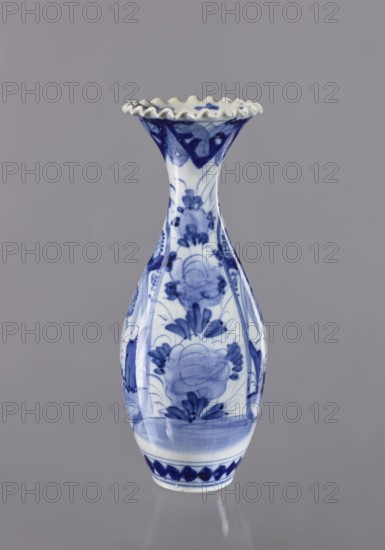 Vase, ceramics, blue and white porcelain, Japanese, 19th/20th century; plant ornament decoration; vessel, height 36.6 cm, diameter 14 cm;, A tall ceramic vase with a flared, scalloped rim displayed against a plain gray background; the vase is predominantly white with blue painted floral and decorative motifs, showing stylized blossoms and leafy patterns on its bulbous body and a banded decorative border near the base, with darker and lighter shades of blue creating depth and brushstroke texture across the surface.