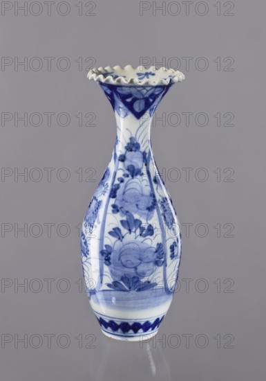 Vase, ceramics, blue and white porcelain, Japanese, 19th/20th century, plant ornaments, vessel, height 36.6 cm, diameter 14 cm, A slender ceramic vase with a flared, ruffled rim, decorated in blue on a white ground. The body narrows at the neck and widens toward the base, showing floral and foliate motifs painted in shades of blue. The rim has darker blue accents, and bands of blue patterning appear near the base. The background is a smooth gray.