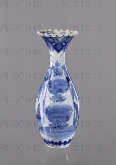Vase, ceramics, blue and white porcelain, Japanese art, vases, Japanese culture, plant ornaments, 19th/20th century, Japan, vessel; height 36.6 cm, diameter 14 cm., A tall ceramic vase with a flared, ruffled rim sits against a plain gray background; the vase is white with blue hand-painted decorative floral and abstract motifs covering its body and neck, showing brushstroke textures and gradients of blue from deep to lighter shades, and the rim interior appears mainly white with blue accents while the lower edge has a band of darker blue pattern.