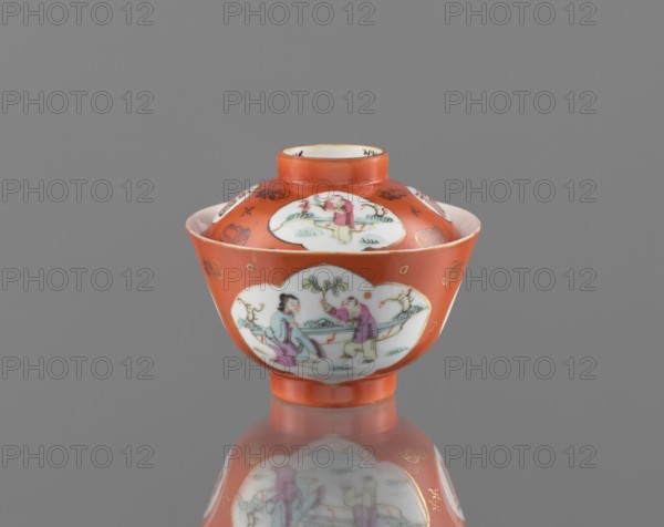 Bowl with a lid;, ; Qing dynasty 1644–1911, Tongzhi period 1862–1874; Chinese; colored porcelain ceramics; vessel decorated with bats and swastikas and genre scenes, with bats and swastikas loosely placed in the background of the decoration; height 8.6 cm, diameter 10.3 cm., A small lidded bowl with a rounded body and short foot, painted predominantly in orange with white cartouche-shaped panels showing scenes of human figures and foliage; the lid and body feature several of these white panels bordered by orange, with delicate painted details in pink, green, blue, and black, and small gold decorative accents on the orange background; the interior rim of the lid appears white and the bowl sits on a reflective grey surface that mirrors its colors and shapes, set against a plain grey backdrop.