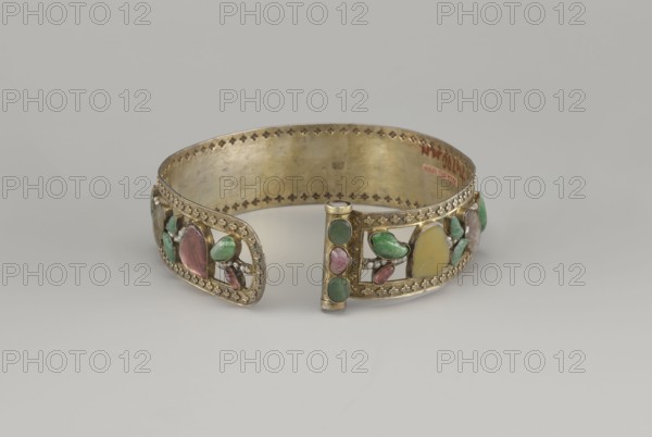 Headband, plant ornament, Chinese art, Chinese culture, Qing dynasty 1644–1911, head ornament, openwork inlaid with glass, semi-precious stones, river pearls and beads, 19th century, China, height 3.3 cm, diameter 12 cm, A gold-toned metal open bracelet with decorative cutouts and a beaded border, set with several oval and leaf-shaped stones in green, pink, yellow, and translucent pale tones, arranged in small clusters and framed by ornate filigree work, photographed against a pale gray background.