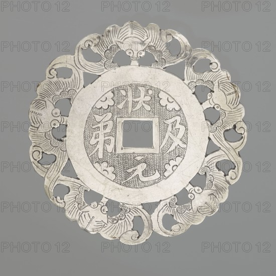 Pendant - amulet of good fortune;, gift; Chinese art; Chinese culture; amulet decorated with bats; 19th century, China; decoration; diameter 5.8 cm, A round, ornate metal object with a scalloped outer edge and an open square center, featuring intricate cutouts and carved decorative patterns; the piece shows engraved motifs around the central opening and along the border, and appears primarily in shades of silver and gray against a muted gray background.
