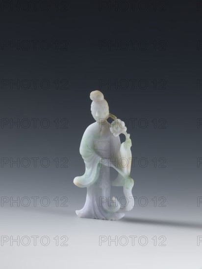 Taoist goddess?, Chinese, Chinese art, goddesses, Qing dynasty 1644–1911, Taoism, flowers iconography, scepters, green-pink slightly translucent jade, 2nd half of the 18th century, China, figurine sculpture, height 17.1 cm, A small carved figurine of a standing person with a rounded topknot hairstyle, flowing robes, and a graceful posture, holding a flowering branch; the material is smooth and slightly translucent with pale colors including white, light green, and soft lavender, with subtle yellowish accents, set against a dark gray to black gradient background and resting on a light gray surface that casts a soft shadow.