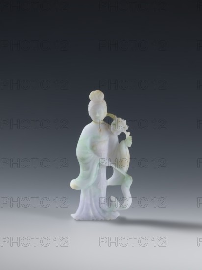 Taoist goddess?;, Chinese; Qing dynasty 1644–1911; Taoism; flowers iconography; scepter; green-pink slightly translucent jade; figurine sculpture; second half of the 18th century; height 17.1 cm, A carved figurine of a standing person made of pale stone with areas of green and lavender hues, wearing flowing robes with soft curves and folds, a rounded bun hairstyle, and holding a floral element near one shoulder; the surface shows smooth, translucent qualities and subtle color variations in white, light green, and pale purple against a neutral gray gradient background.
