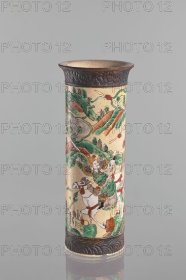Vase, Chang author's role classification / workshop, knightly scenes, ceramics, Chinese art, Chinese culture, cylindrical vessel with flared rim. Cracked iron-sand glaze. Decorated with a scene of a knightly procession in a landscape a mirror equivalent of the decoration on the second vase in the pair. At the foot and at the rim, a band imitating a bronze representation. 19th century, China. Vessel. Height 31 cm, diameter 12 cm., A tall cylindrical ceramic vase stands against a plain light gray background, decorated with a painted scene in muted greens, browns, reds, black, and cream. The vase has a dark brown textured band at the top rim and a matching band at the base, while the main body shows a continuous narrative scene featuring figures in flowing garments, riders on horses, stylized trees and mountains, and scattered decorative elements. The painted figures wear garments and accessories in green and brown tones, the horses are primarily cream with brown and black details, and th...
