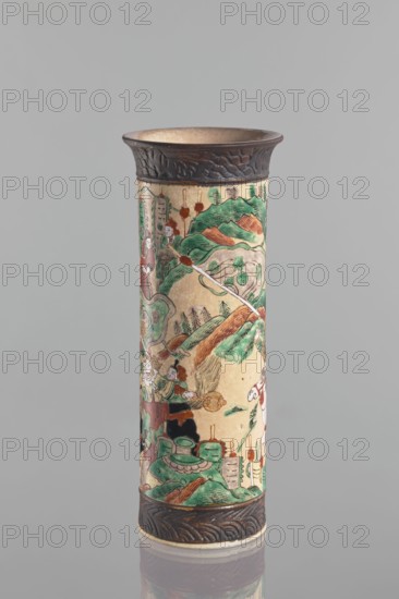 Vase, Chang author's role classification, workshop author; knightly scenes; ceramics; Chinese art; Chinese culture; cylindrical vessel with flared rim; cracked iron-sand glaze; decorated with a scene of a knightly procession in a landscape a mirror equivalent of the decoration on the paired vase; band imitating a bronze representation at the foot and rim; 19th century, China; vessel; height 31 cm, diameter 12 cm., A tall cylindrical ceramic vase with a flared dark brown rim and matching dark brown base, decorated with a colorful painted scene featuring a group of human figures amid stylized landscape elements; visible colors include green, brown, beige, red, white, black, and touches of orange. The painted imagery shows rolling green hills with brown highlights, winding paths, and clusters of stylized trees in green and black, with a few figures wearing garments in red, green, and white engaged in various activities; there are also decorative motifs such as rounded shapes and cloud-lik...