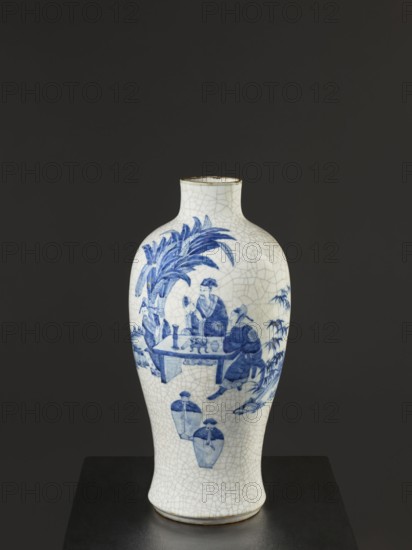 Vase, figurative scenes, ceramics, gardens, Chinese art, Chinese culture, blue and white porcelain, cracklework decoration, Qing 1644–1911, 18th/19th century Jiaqing period, 1797–1820, Qing dynasty, China, vessel, height 54.5 cm, A white ceramic vase with a crackle glaze stands against a dark gray background on a dark surface, decorated in blue with a scene showing a group of people seated around a low table beneath large leafy plants, additional foliage and two jar shapes depicted lower on the body, the vase has a narrow neck with a slightly flared rim and a rounded, tapering body; visible colors include white, blue, dark gray, and a thin line of brown around the rim.
