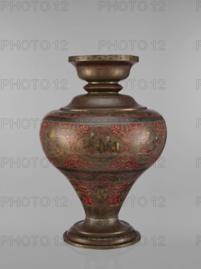 Vase, 19th century, India. Vase with a bulging, flattened belly tapering to the bottom; wide spout and round foot. Polychrome in red, pink, yellow, white and black. Decorated with jugs, gods, teachers, Vishnu, Shiva, fish, plant and geometric ornaments, and ascetics. Vessel, height 50.0 cm, diameter 13.0 cm, weight 5.75 kg., A rounded ornate vessel with a flared neck and a pedestal base, decorated with intricate painted scenes and floral motifs; the surface shows a combination of metallic brown and gold tones with prominent red areas and touches of black and green, with several circular medallions containing small figurative vignettes, bands of patterned ornament around the neck and foot, and leafy vine-like designs filling the spaces between the medallions.