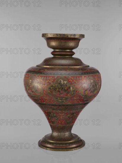 Vase, 19th century, India. Vase with a bulging, flattened belly tapering toward the bottom; wide spout and round foot. Polychrome in red, pink, yellow, white and black. Height 50.0 cm, diameter 13.0 cm, weight 5.75 kg. Decorative program: Hindu subjects Vaishnavism, Shaivism depicting gods Vishnu, Shiva, teachers, ascetics; motifs include fish, plant and geometric ornaments; jugs/containers., An ornate rounded vessel with a flared neck and pedestal base sits against a plain gray background; its surface displays a dominant red color with extensive gold and dark brown metallic detailing, including patterned bands and decorative floral motifs, and several medallion-like scenes rendered in darker tones surrounded by gold highlights; the neck, shoulder, and base show etched or engraved feather-like patterns in brown and gold, while the midsection has red panels filled with stylized leaves and floral elements in gold and darker red, and the foot and lip carry concentric bands of brown and go...
