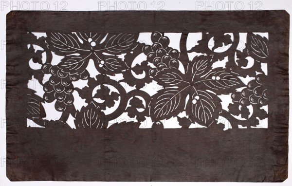 Dyeing stencil katagami with a grape and plant twig motif budô ni karakusa moyô, ise-katagami, chuban format; stencil; plant ornaments, grapes, karakusa pattern; Meiji period 19th/20th century, 1868–1912, Japan; height 40.5 cm, width 25.2 cm., A rectangular sheet with a dark brown foreground cut into an ornate horizontal band near the top, revealing a white background through an intricate pattern of large stylized leaves, curling vines, and clusters of rounded berries; the dark brown material shows uneven texture and slight wrinkles, especially toward the lower portion and edges, and the white behind emphasizes the negative-space floral design.