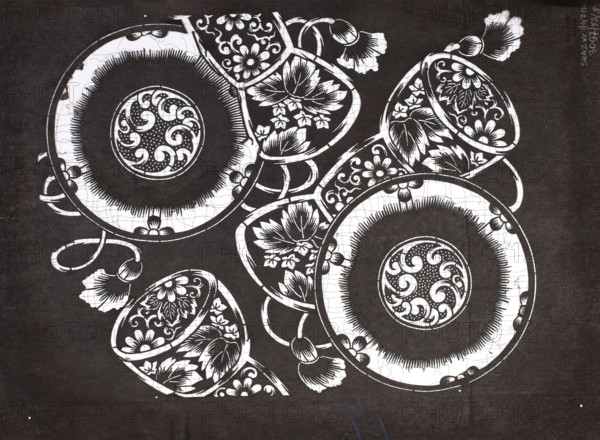 Dyeing stencil katagami with tsuzumi drum motif, ise-katagami stencil, chuban format, late 19th century Meiji period, Japan. Subject: tsuzumi drums and floral ornaments. Materials/technique: stencil katagami. Dimensions: height 40.6 cm, width 30.5 cm. /author., The image shows a high-contrast black-and-white composition of decorative round plates and teacups arranged overlapping each other, each featuring intricate floral and swirling motifs; the background is dark while the objects are primarily white with black detailing, and there are a few floral-shaped handles or embellishments extending from the ceramics.