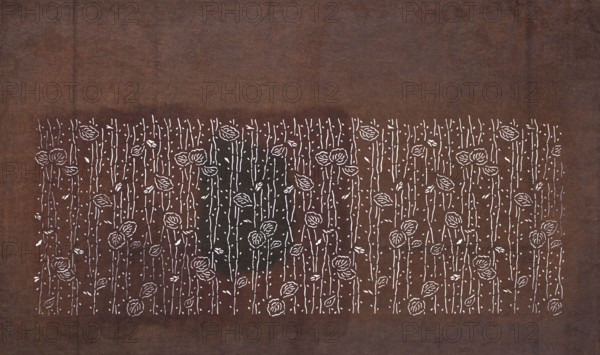 Katagami dyeing stencil with a leaf motif on branches eda ni ha moyô, creator unknown, chuban format stencil, leaves and branches motif, katagami, 19th century Edo–Meiji periods, Japan; height 41.2 cm, width 24.9 cm., A rectangular fabric or paper surface in shades of brown with a darker brown central band contains a repeating hand-drawn pattern of stylized flowers and vertical stems in white; the flowers have rounded petal shapes and there are small leaf shapes and dot accents scattered among the stems, creating a dense, regular floral field against the brown background.