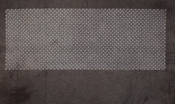 Katagami dyeing stencil with a stylized checkered pattern kawari ichimatsu, unknown author, ise-katagami stencil in chuban format, geometric checkered ornament, Meiji period, 2nd half of the 19th century Japan, stencil; height 41.1 cm, width 25.8 cm., A large dark textured surface fills the image with a rectangular area near the top made up of a dense grid of small light dots forming repeating geometric patterns, surrounded by the darker background. The visible colors are dark gray and black for the background texture and white for the dot pattern, with subtle variations of lighter and darker gray in the textured areas.