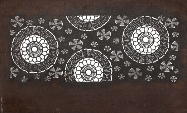 Katagami dyeing stencil with a motif of stylized floral rosettes kawari kamon moyô, ise-katagami stencil, chuban format, geometric and plant patterns, Japan, 2nd half of the 19th century late Edo–Meiji, height 40.6 cm, width 24.8 cm., A dark brown rectangular background with a large horizontal black rectangle across the upper portion containing decorative white circular mandala-like patterns and several smaller white pinwheel motifs; the mandalas have petal shapes and concentric ring details, and a few of them are partially cut off by the top edge of the black area, while the lower portion of the brown background is mostly plain.